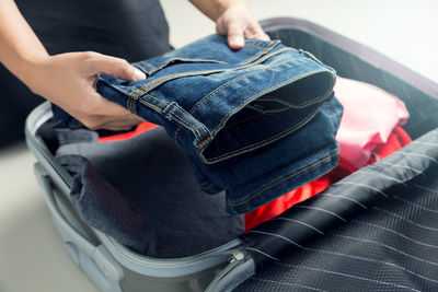 Midsection of person holding jeans