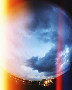 Rainbow over illuminated city at night