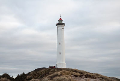 Low angle view of lighthouse amidst buildings against sky