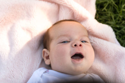 Close-up portrait of cute baby boy lying on bed