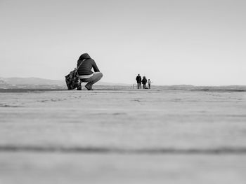 People on beach against clear sky