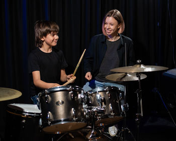 Portrait of young man playing drum at home