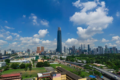 Aerial view of buildings in city against cloudy sky