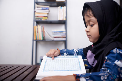 Portrait of boy looking at book