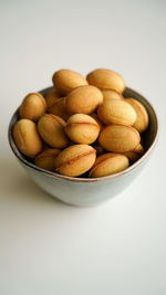 Close-up of peanuts in bowl on white background