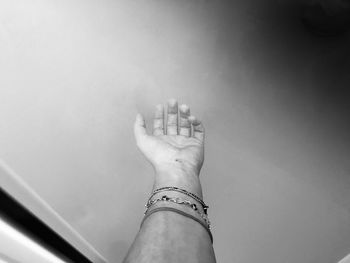 Cropped hand of woman reaching wall