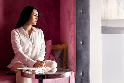 Portrait of young woman sitting at home