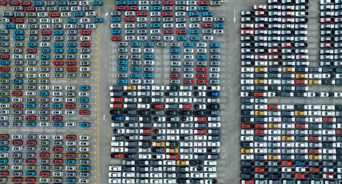 Aerial view of new cars stock at factory parking lot. above view cars parked in a row. automotive 