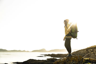 Woman exploring the coastline with backpack