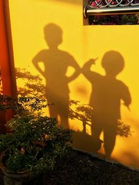 Shadow of people on yellow wall