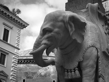 Low angle view of statue against building in city