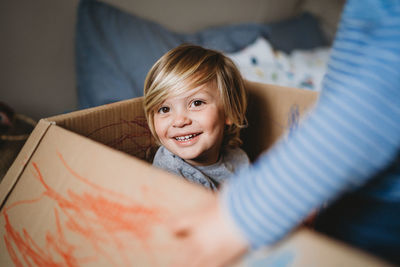 Young male child smiling looking at the camera playing in a box