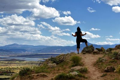 Man walking on mountain against sky