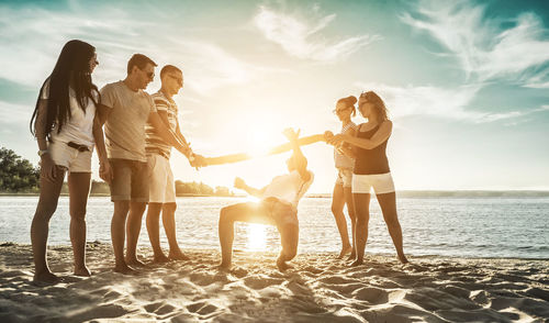 Rear view of friends standing at beach