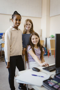 Portrait of multiracial female students in computer class at school