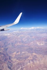 Airplane wing flying over clouds in sky