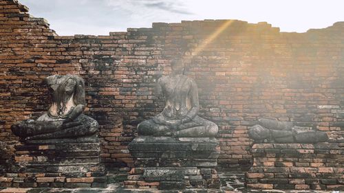 Statue against brick wall of historic building