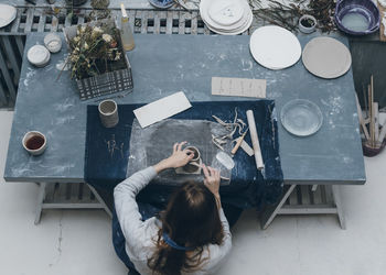 High angle view of woman making clay cup