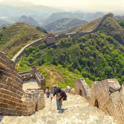 People walking on great wall of china during sunny day