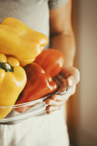 Midsection of woman holding red bell pepper