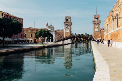 Canal and venetian arsenal against sky