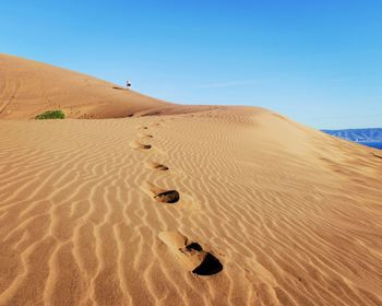 Sand dunes in desert against clear sky