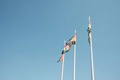 Low angle view of flag against clear blue sky