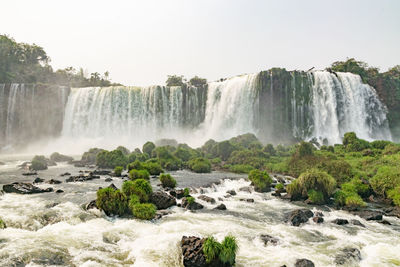 Scenic view of waterfall against sky