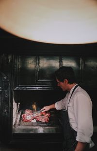 Side view of a man preparing food