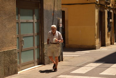 Full length of man walking on footpath