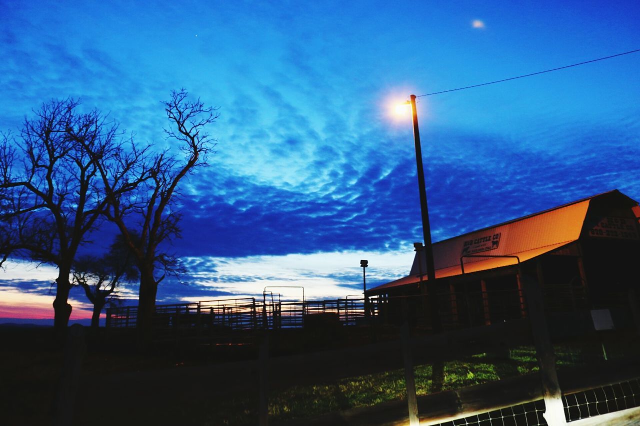 sky, cloud - sky, blue, street light, built structure, cloud, dusk, architecture, nature, tree, sunset, silhouette, railing, tranquility, building exterior, lighting equipment, beauty in nature, illuminated, scenics, cloudy