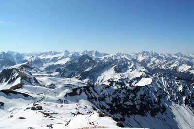 Scenic view of snowcapped mountains against clear blue sky