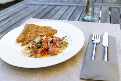 Das foto zeigt einen leichten sommerlichen fischsalat auf einen rustikalen holztisch angerichtet