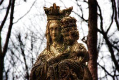 Low angle view of statue against bare trees