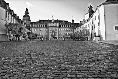 Cobblestone street amidst buildings against sky