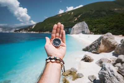 Midsection of person holding rock in water