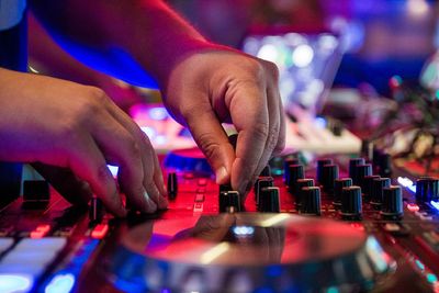 Cropped hand of man using audio equipment in club