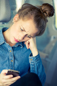 Young woman using mobile phone on the train