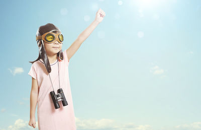 Girl wearing sunglasses while standing against sky