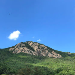 Scenic view of mountains against blue sky