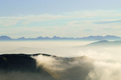 Scenic view of mountains against cloudy sky