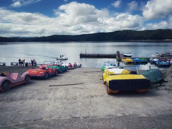 Boats moored on lake against sky