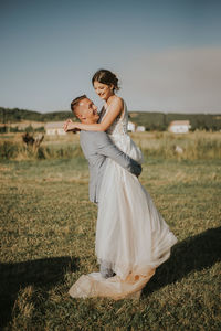 Married couple standing on field