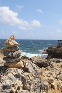 Stack of rocks on beach against sky