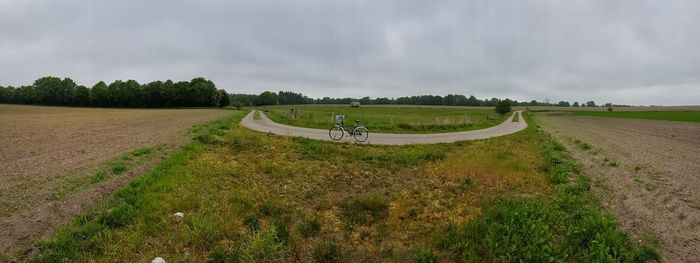 Panoramic view of people riding motorcycle on road