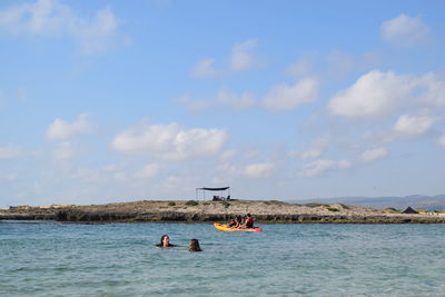 People on sea against sky