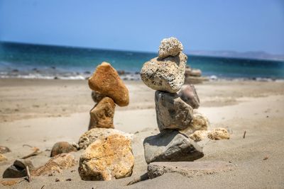 Stack of rocks on beach against sky