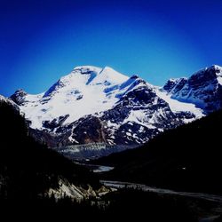 Scenic view of snowcapped mountain against blue sky