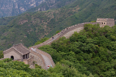 Great wall of china by trees on mountains