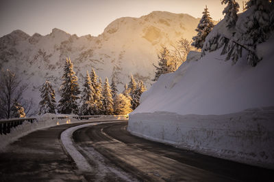 Road amidst snowcapped mountains against sky during winter